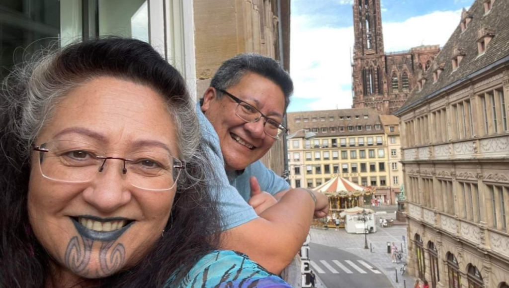 Elizabeth and her wife Alofa take a selfie from a balcony high above a European city.
